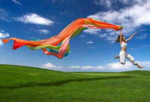 Young beautiful woman jumping with a scarf